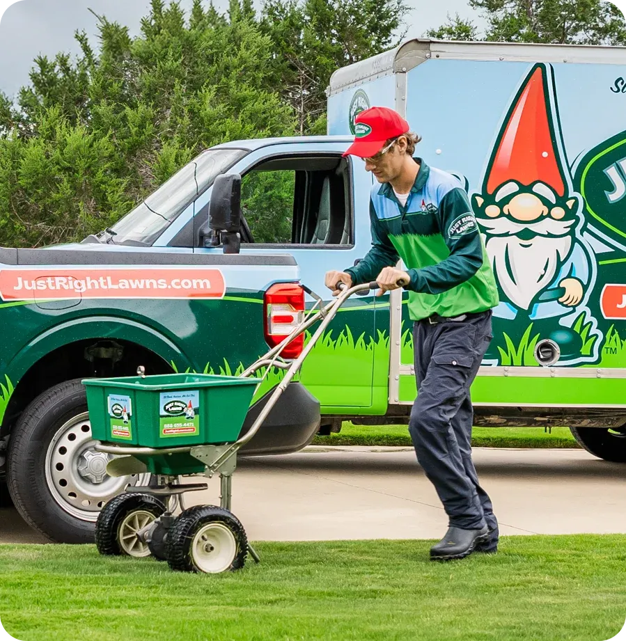 Just Right Lawns technician standing next to company vehicles