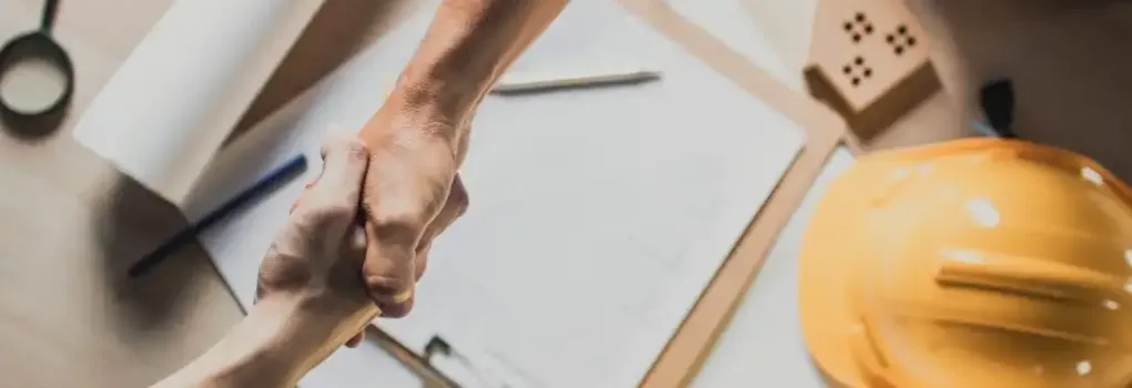 top-view-hand-shake-of-engineer-and-building-contractor-on-table