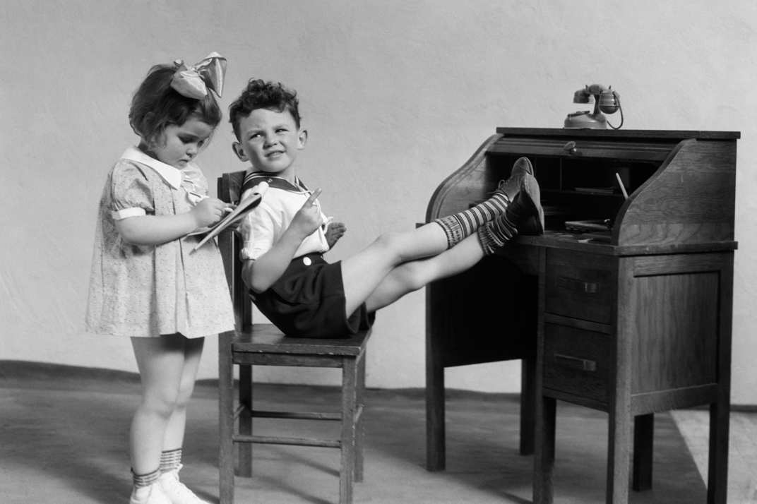 Children sitting at desk working like adults