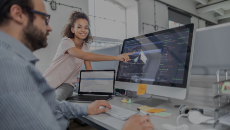 woman pointing at computer screen where developer is coding